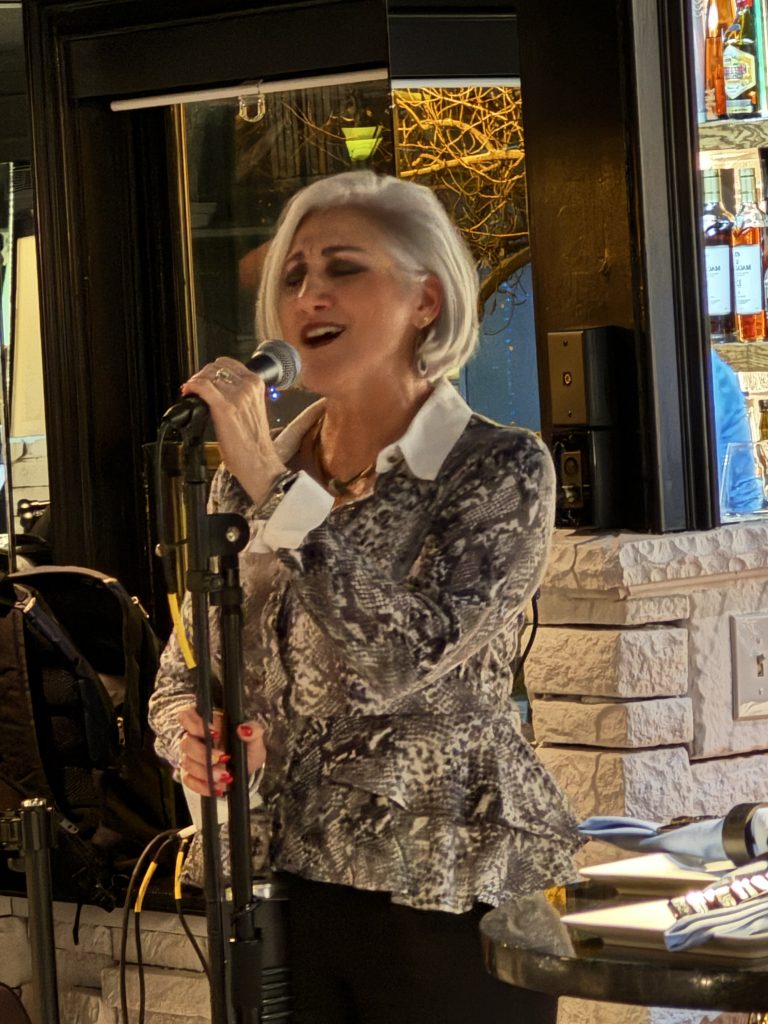 Judy Arnold singing at a microphone.