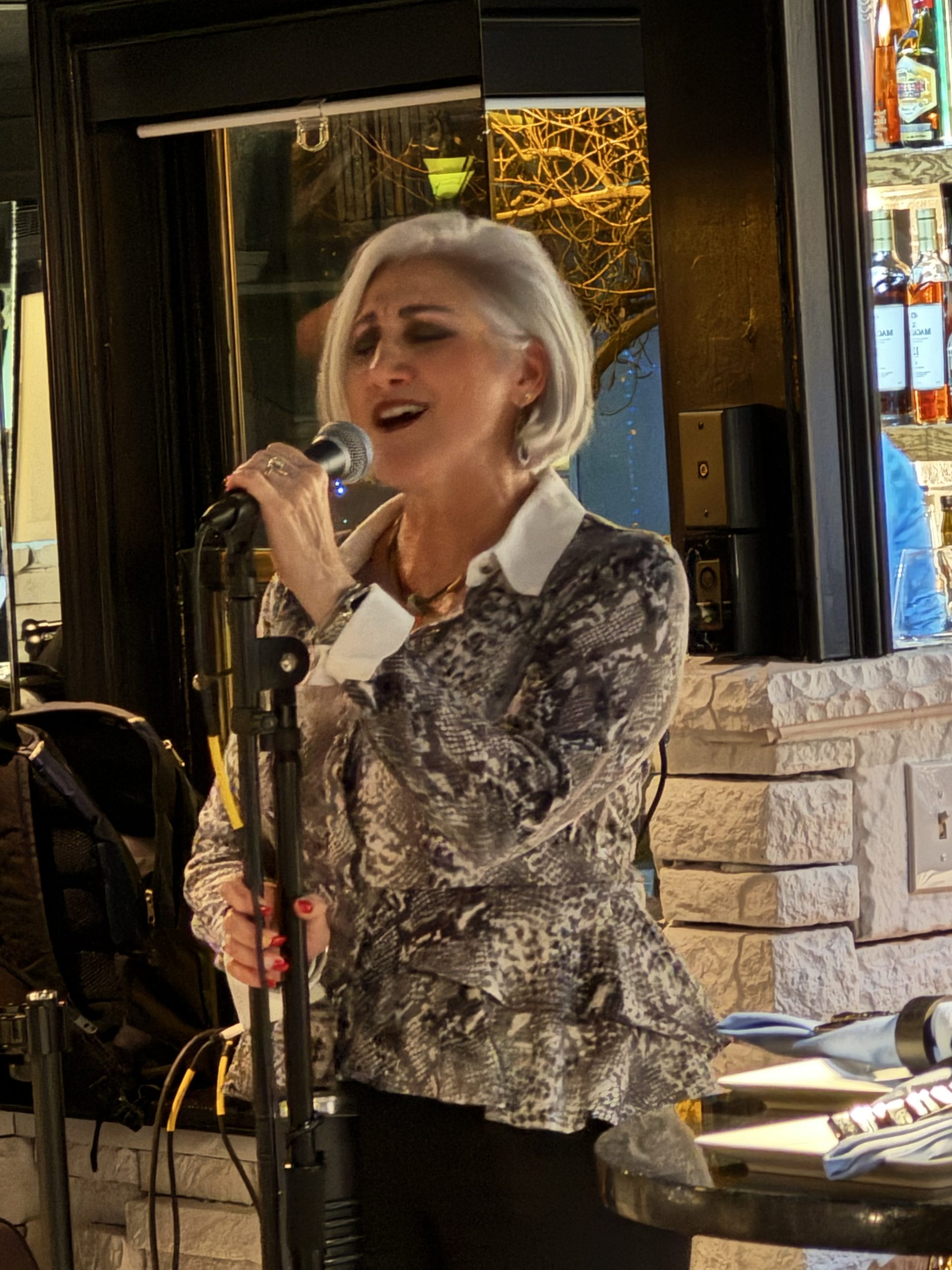 Judy Arnold singing at a microphone.